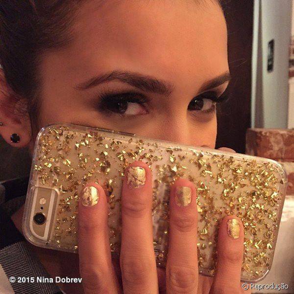 Aqui, Nina combinou a sua manicure dourada craquelada com a capinha de seu celular